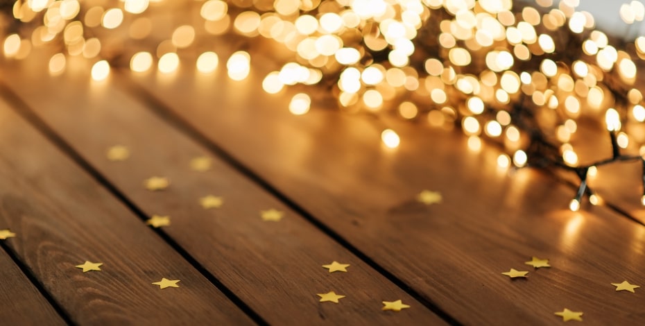 Abstract image of glowing lights and gold stars on wooden boards.