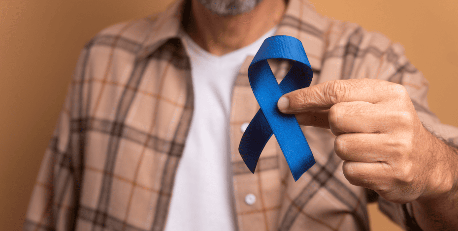 A person holds a blue ribbon for prostate cancer awareness