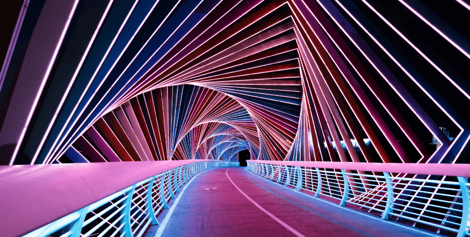 An illuminated pedestrian bridge with funky colours