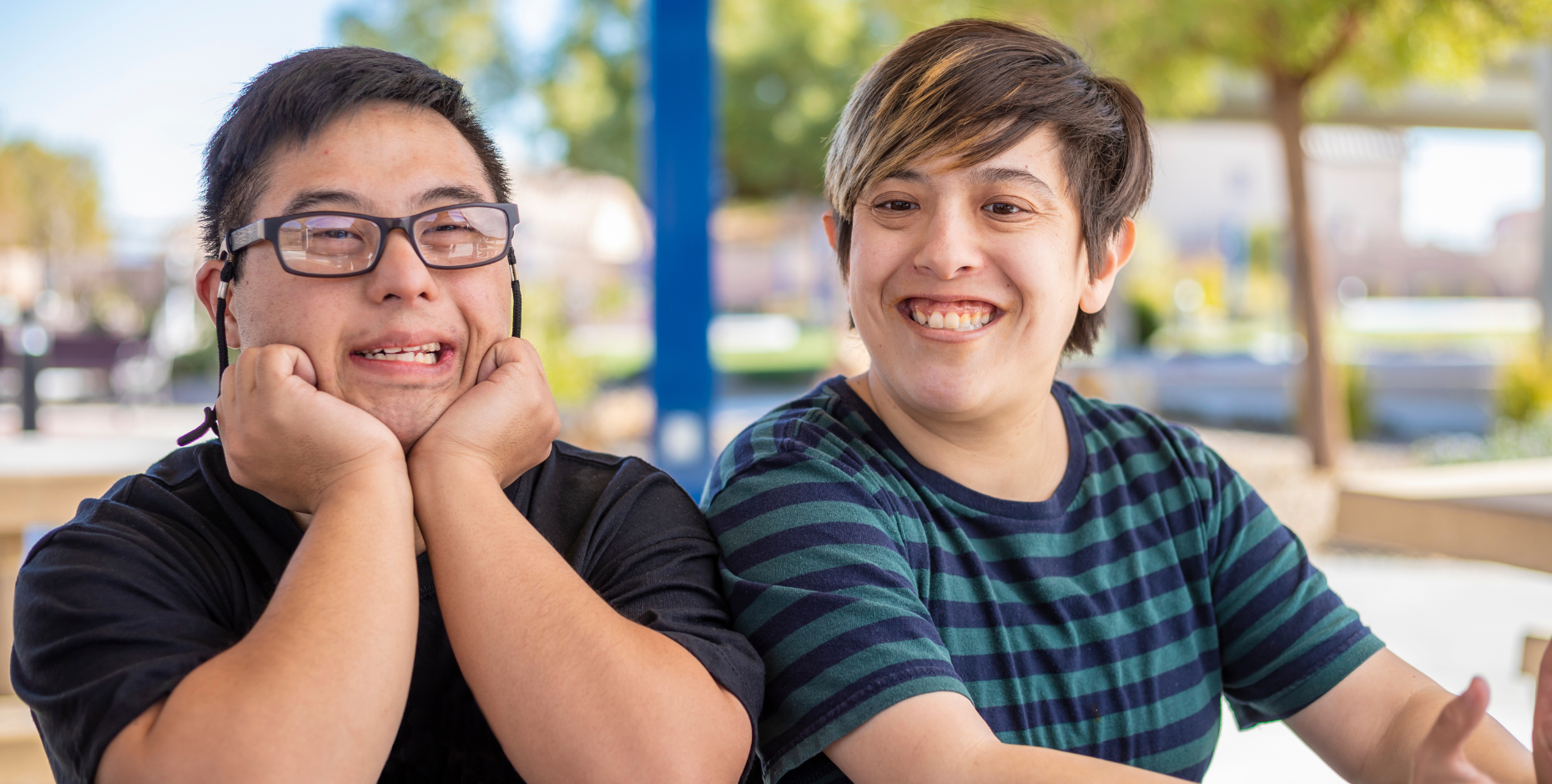 Two young people living with disability smiling at the camera