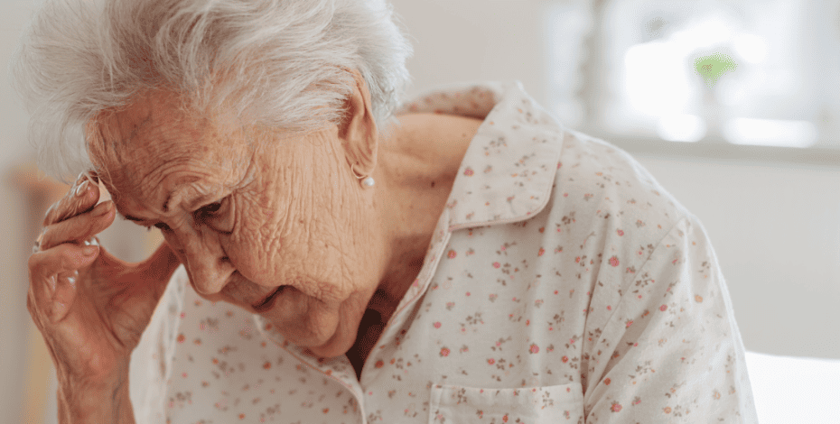 Elderly woman clutching her head