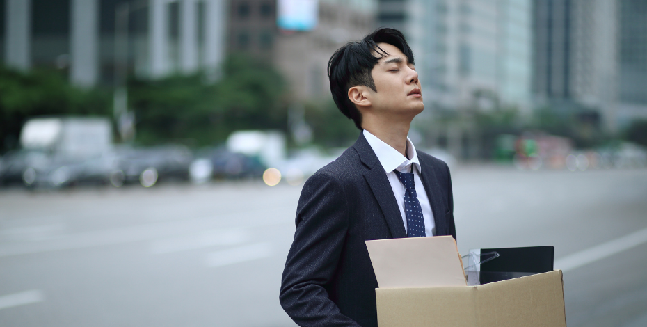 A man holding a box of his belongings after being made redundant 