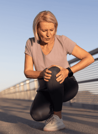 Woman clutches her sore knee