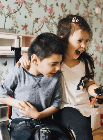 A boy with cerebral palsy playing with his sister