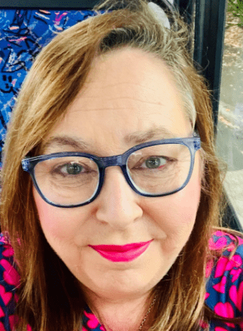 A woman wearing a patterned shirt and glasses