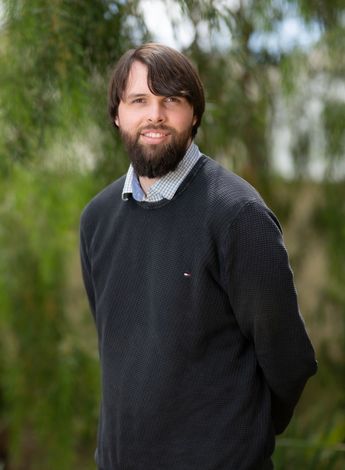 The image is of physiotherapy educator Ryan McGrath standing outside. 
