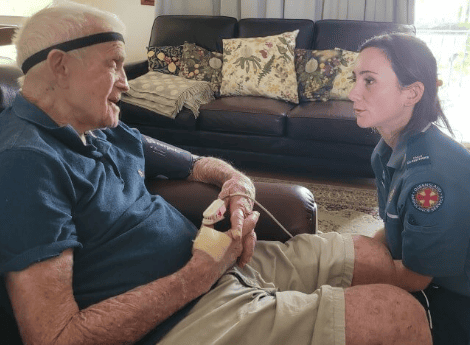 Natalie assesses a patient after he experienced a fall in the home. Photo: Queensland Ambulance Service