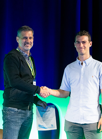 Two men are shaking hands on stage. 