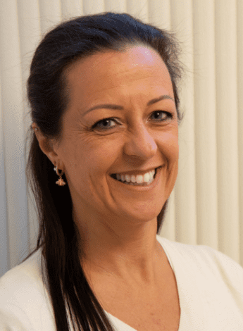 The image is of a woman with long dark brown hair, wearing a white top.