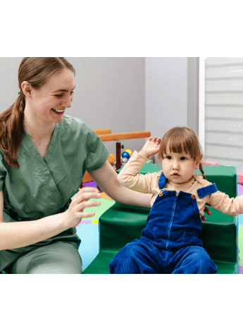 A physiotherapist working with a young girl with neuro-development issues
