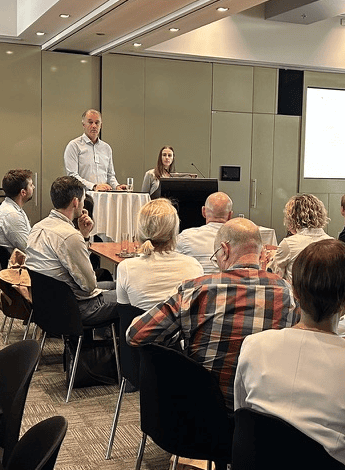 A group of osteoarthritis researchers listen to a speaker at a meeting. 