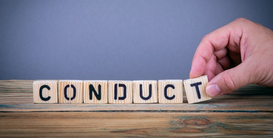 Wooden blocks on a desk spell out 'CONDUCT'.