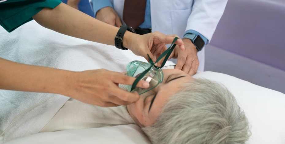 Medical staff fit ventilating equipment to a patient's face. 