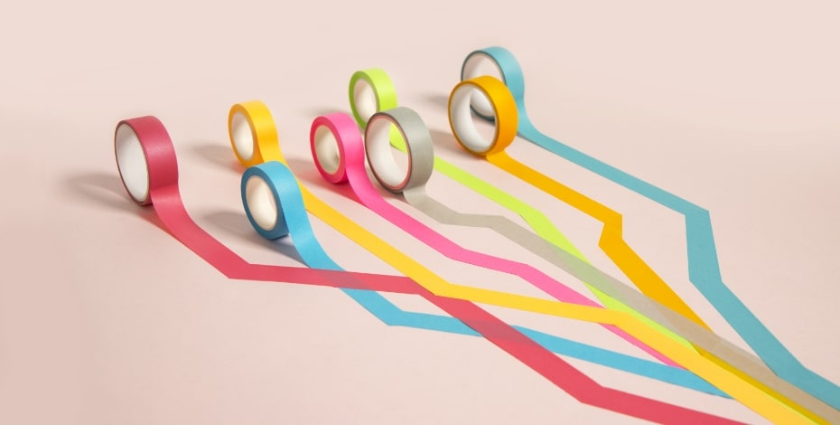 Rolls of tape in multiple colours are stuck along the ground in meandering paths.