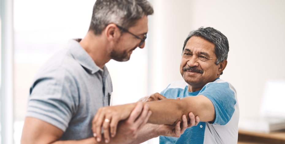 A physio looking at a man's outstretched arm