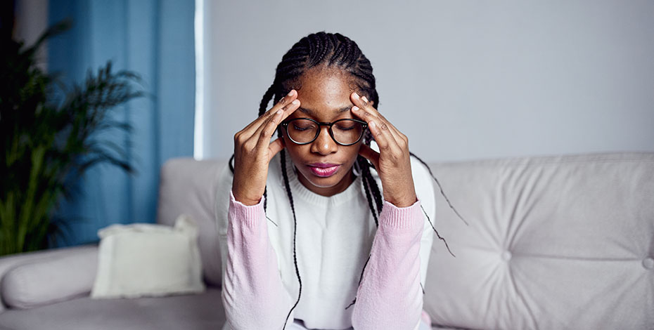 Woman with her hands to her head as if indicating where her headache is.