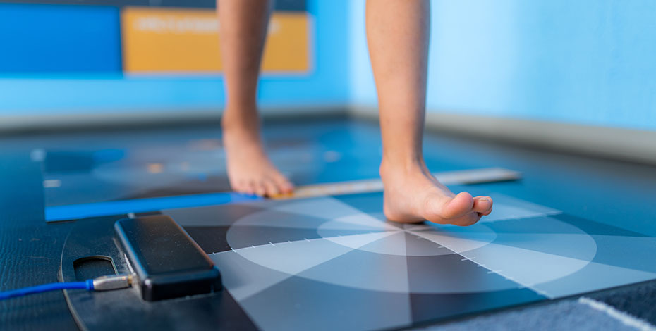 A person's lower legs and feet as they step onto testing equipment. 