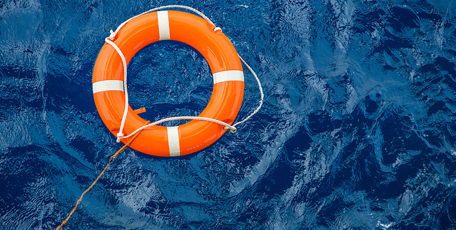 An orange lifesaver floats in the ocean.
