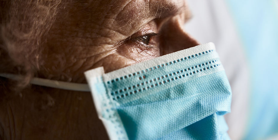 older person looking somber wearing covid mask