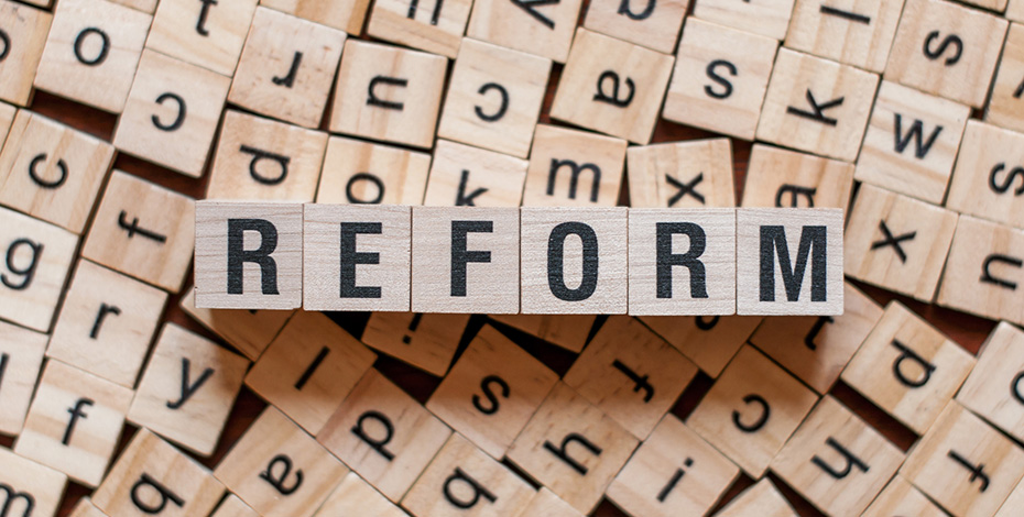 small wooden blocks arranged to spell reform