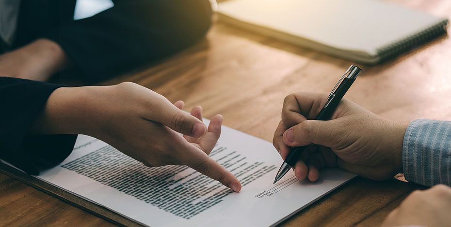 Hands signing a contract.