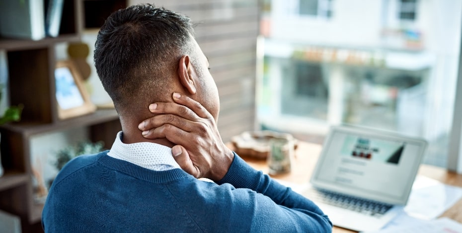 A man rubs his neck as if in pain. 