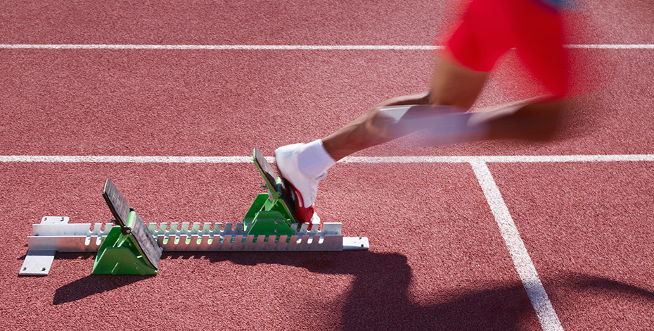 runner taking off from starting blocks