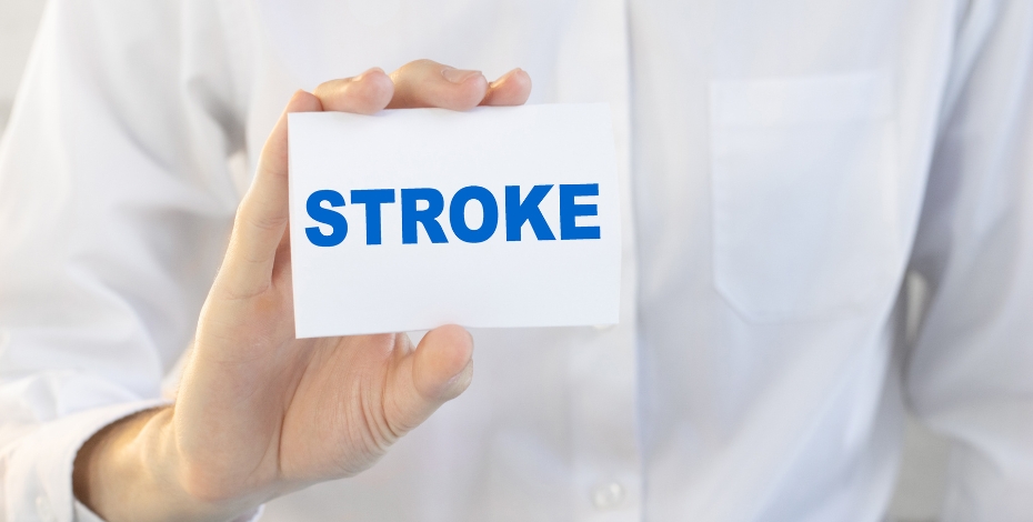 person in a white coat holding a card with the word stroke
