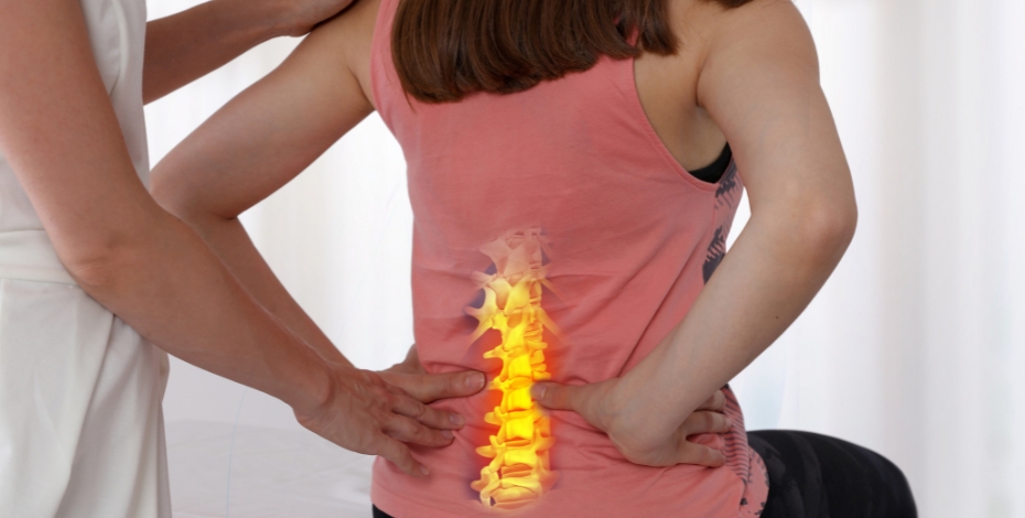 person sitting holding there lower back with the spine inside in pain