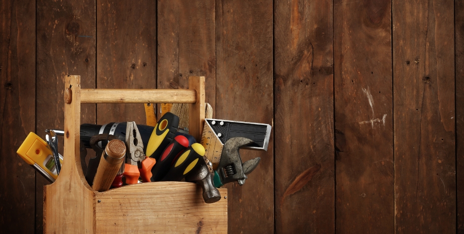 toolbox full of different tools on a wooden background