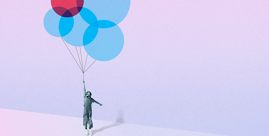 A child holds colourful inflated balloons that are lifting him off the ground.