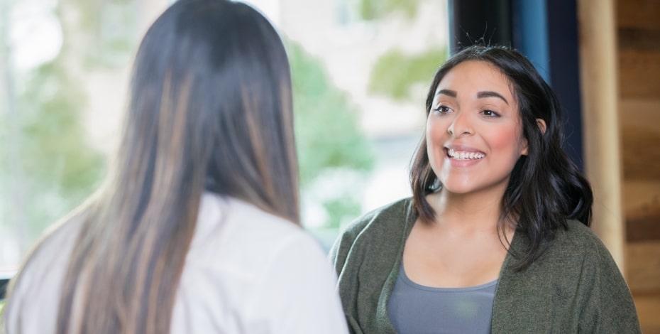 two people conversing one with a big smile