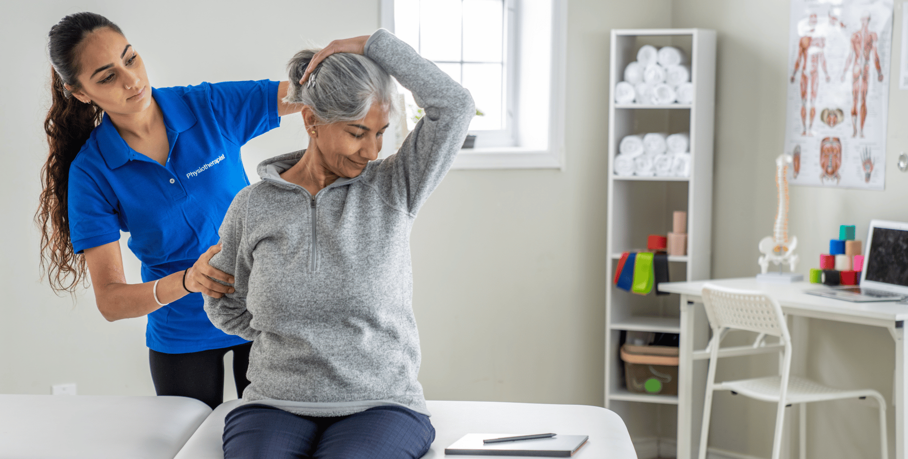 Physiotherapist in a clinic treats an older patient by performing stretches