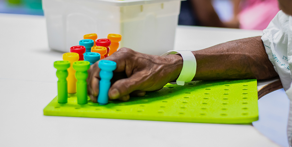 A patient's hand is pictured playing checkers or some game like that. 