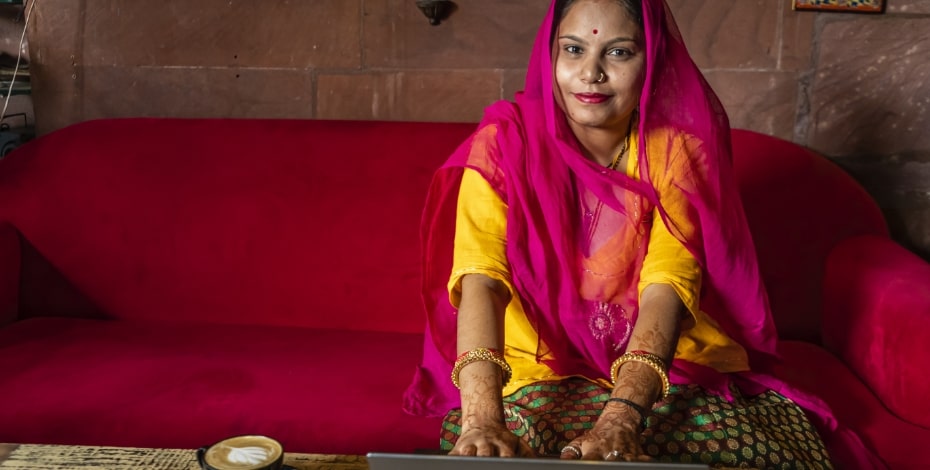 An Indian woman dressed in traditional attire stares intently at the camera.