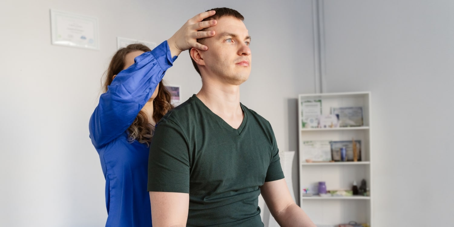physiotherapist adjusting patients neck from behind