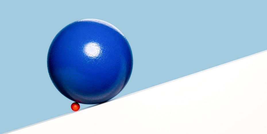 Tiny red ball pushes giant blue ball up a hill.