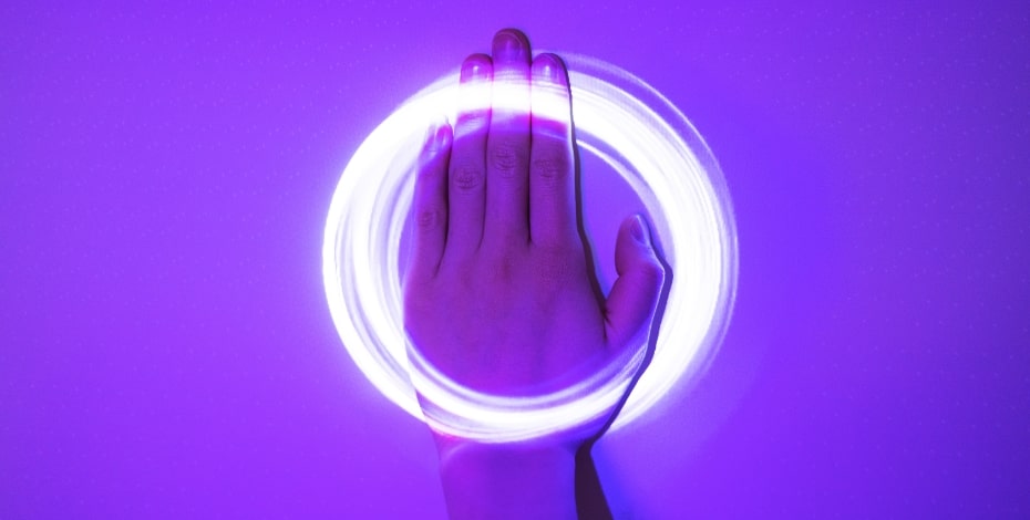 A hand in a circle of light against a purple background