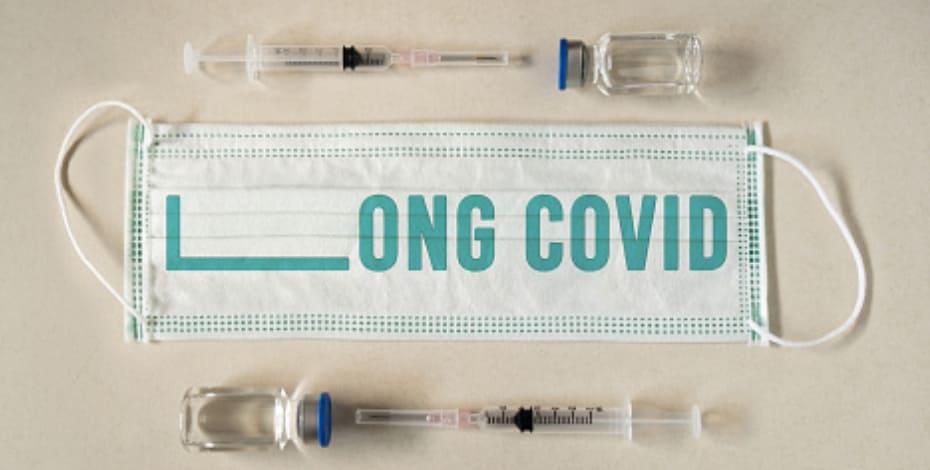 A mask with the text 'Long Covid' on it, surrounded by syringes and vials of medicine.