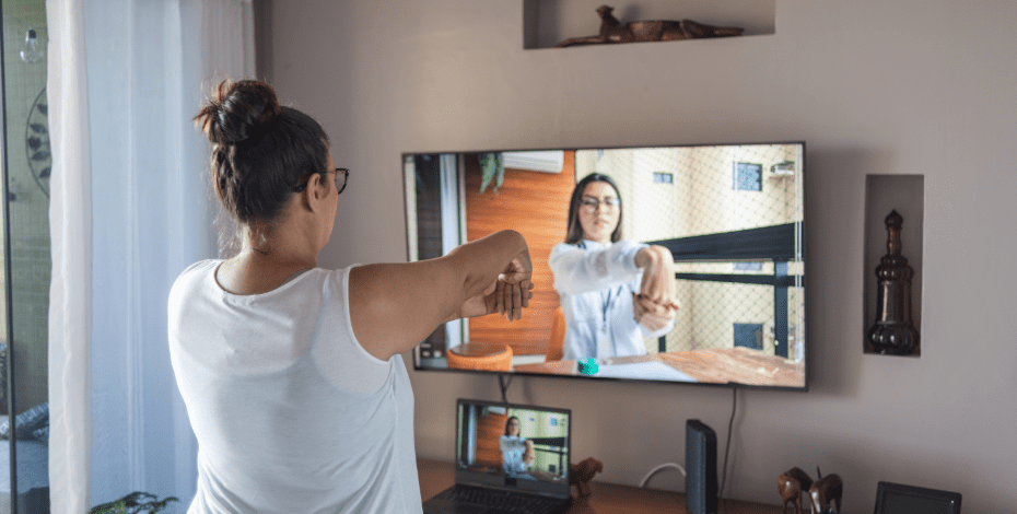 Woman doing exercises while using telehealth