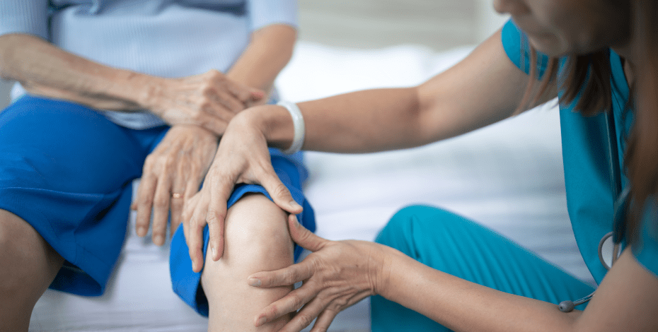 A healthcare professional examines the knee of a patient.