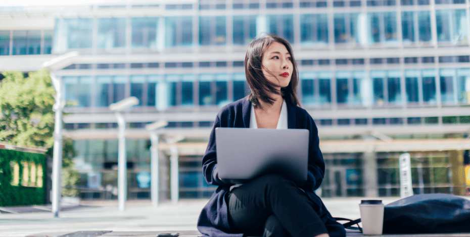 A woman sitting on a bench looks of to the distance as if contemplating updating her business insurance.