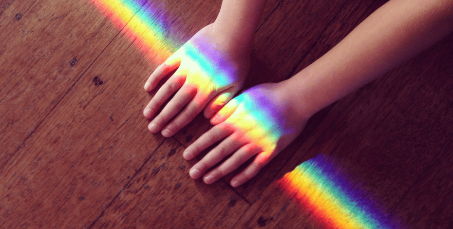 A rainbow crossing over a pair of hands