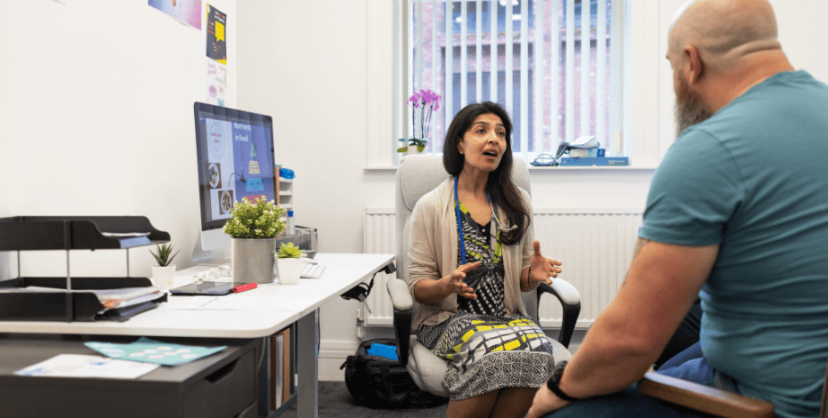 A clinician sitting with a patient in her office. 