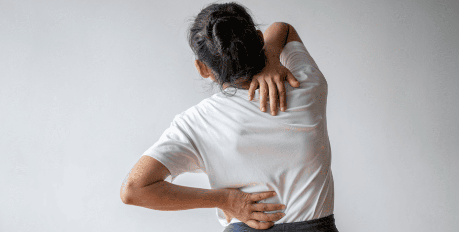 Woman in pain trying to massage her back