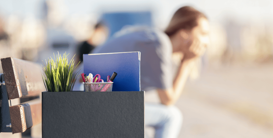 Woman who has been fired, sitting on a bench.