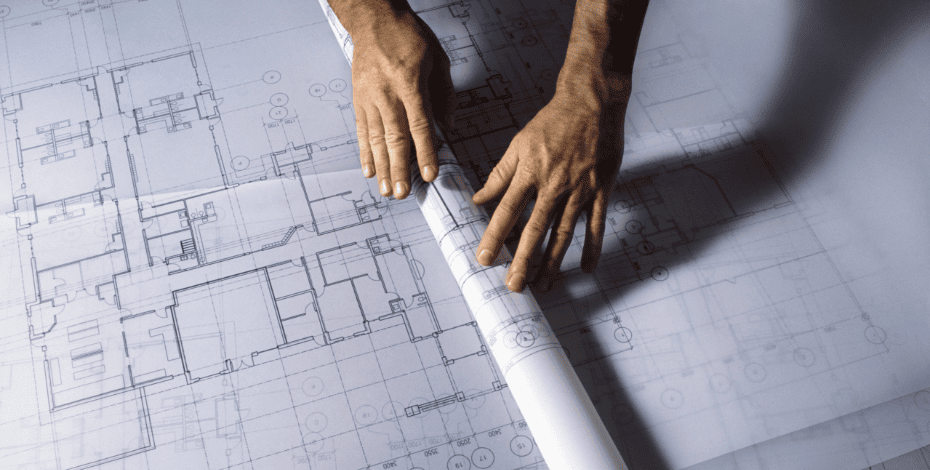 A person rolls out architectural plans