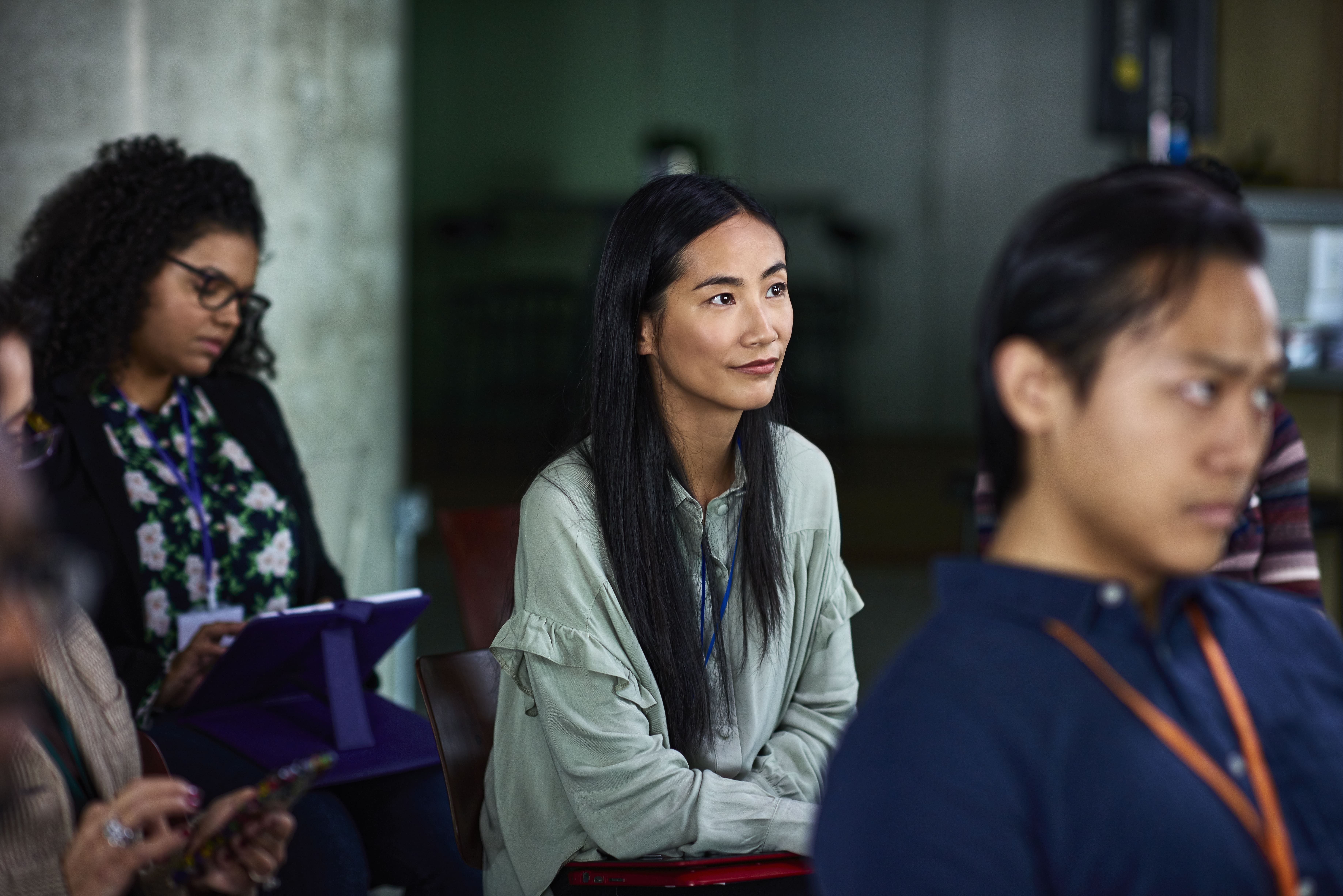 A woman listening intently to a speaker