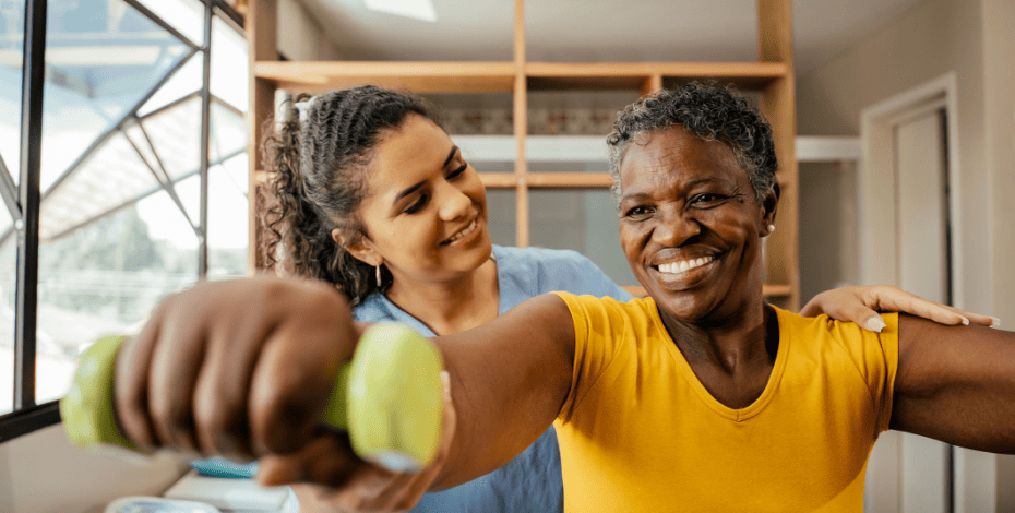 A physiotherapist guides a patient through some arm exercises. 