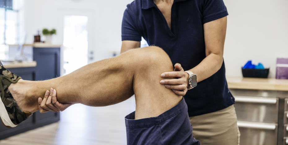 A physiotherapist treats a man's knee pain